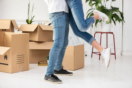 Close-up of happy ouple with cardboard boxes hugging in new home