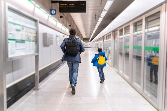 Father and daughter on metro station, girl running away