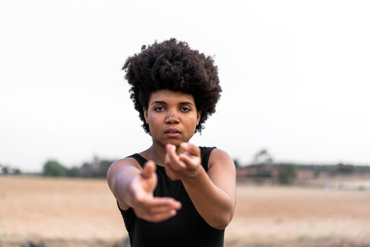 Portrait of young woman reaching out hands for help