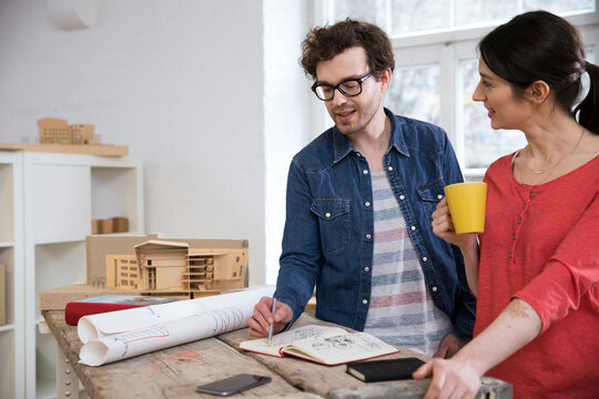 Man and woman discussing draft in office