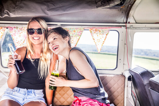 Two happy women inside van with bottles