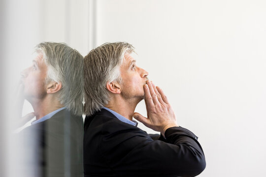 Desperate businessman leaning on window