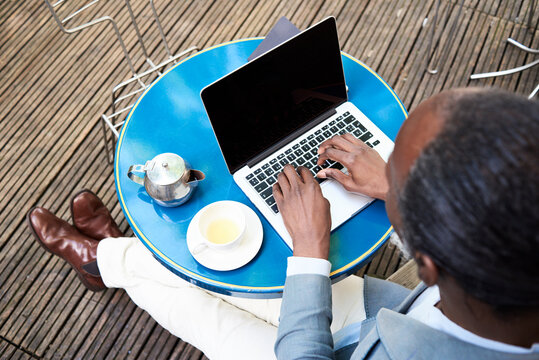 Businessman sitting on terrace using laptop
