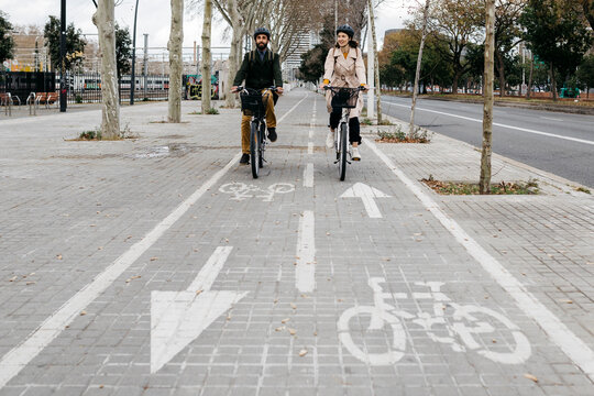 Couple riding e-bikes in the city on bicycle lane