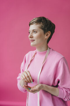 Portrait of smiling tailoress holding buttons