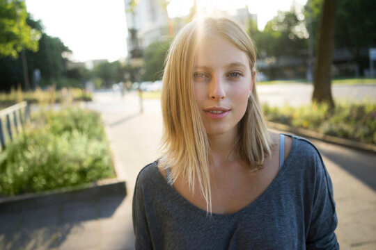 Portrait of blond young woman at backlight