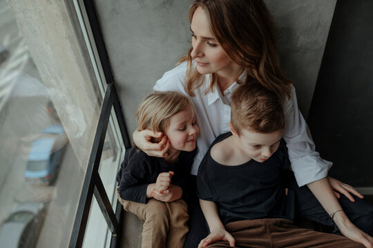 High angle view of woman sitting with sons by window at home