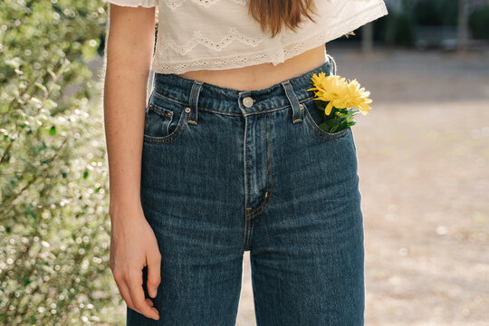 Woman standing with yellow flower in pocket