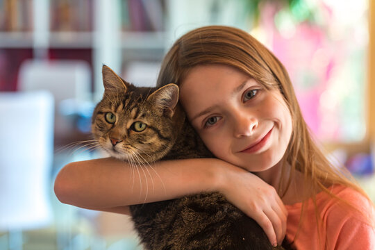 Portrait of smiling girl with her tabby cat