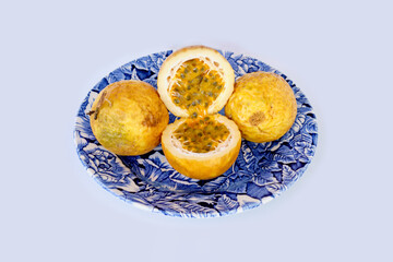 Passion fruit of yellow color lies on a plate