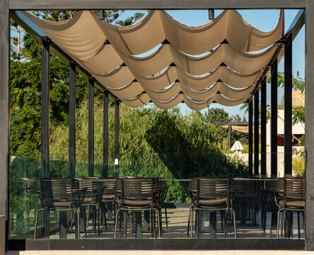 Shaded outdoor dining area with retractable fabric awning