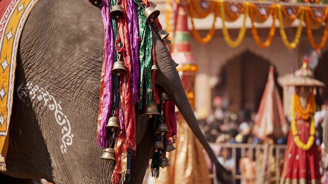 Majestic Elephant Adorned With Colorful Garlands Bells and Ornate Saddlecloth During a Sunny Outdoor Festival Celebration Detailed Close Up of an Animal Displaying Traditional Indian Culture and