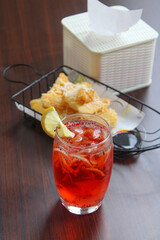 Refreshing red tropical iced mocktail with crispy fried cassava cheese snack