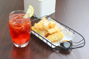 Red tropical fruit ice drink served with crispy fried cassava snack