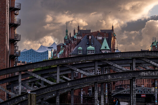 Harbor district skyline with a bridge and dramatic clouds over a waterfront in HafenCity capturing Hamburg Germany urban atmosphere and a striking landmark view