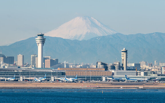 Beautiful view of Tokyo Haneda airport and control tower with snowy mount Fuji in background with winter morning light in Tokyo Japan