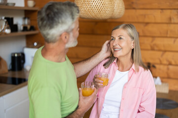 Seniors drinking fresh juice indoors during breakfast