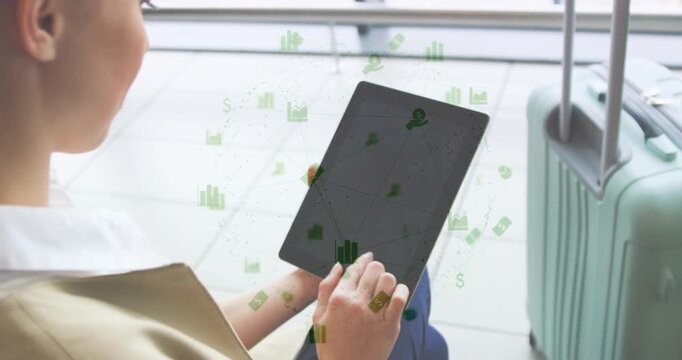 Woman at gate tapping tablet, green finance icons appearing and annotating charts as reviewing data