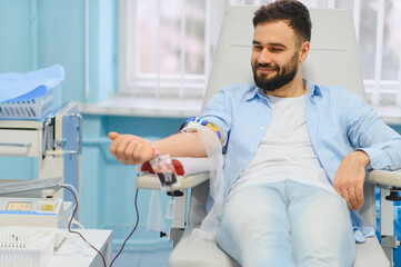 Young man donating blood in medical clinic
