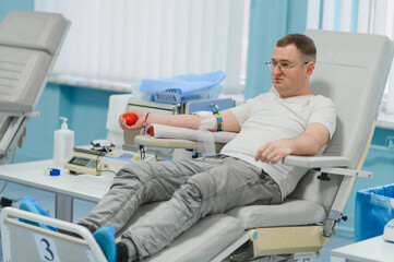 Fototapeta premium Male blood donor sitting in chair at clinic