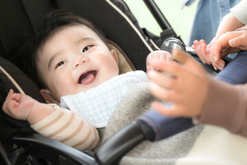 ベビーカーに乗った赤ちゃんをあやす　笑顔の赤ちゃん