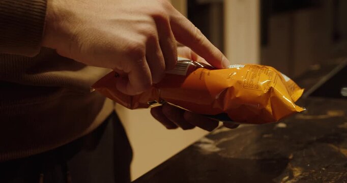 Close-up of a person checking allergen information and calorie values on a packaged food product in the kitchen. Concept of healthy eating, food safety, dietary awareness, and nutrition control.