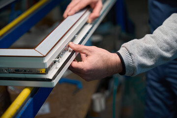 Naklejka premium Professional man worker engaged in assembly of PVC doors and windows