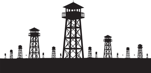 Silhouette of watchtowers and barbed wire fence at night