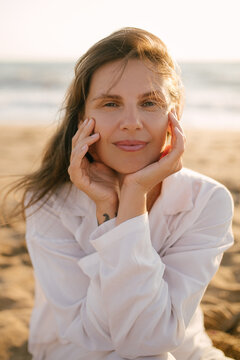 Beautiful 40 years old woman relaxing on the beach at sunset.