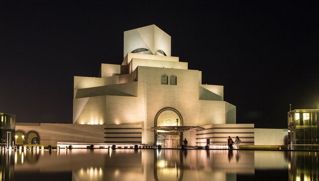 The state museum of islamic art at night beautifully lit with blurred water surface. Doha, Qatar