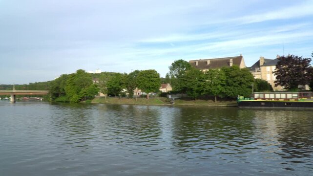 Panning video unveils a captivating view of Oise river flowing through Creil, a city in northern France.