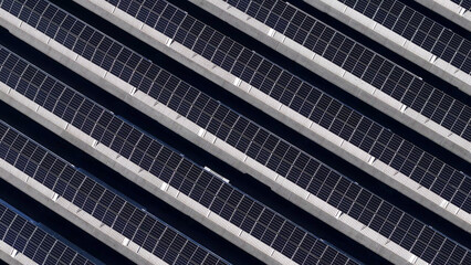Rows of photovoltaic panels generating clean electricity on a utility scale solar farm, an essential part of the global effort towards sustainability and green energy © august.columbo