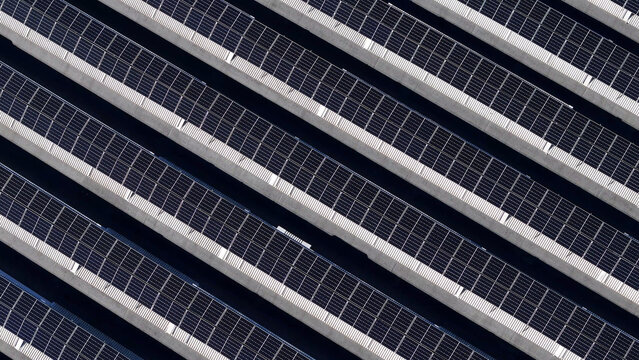 Rows of photovoltaic panels generating clean electricity on a utility scale solar farm, an essential part of the global effort towards sustainability and green energy