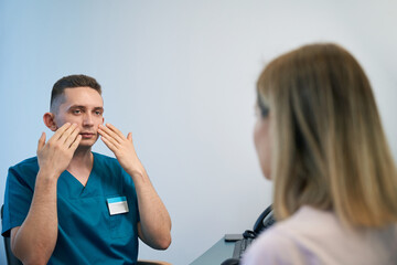 Otolaryngologist consulting female patient at modern ENT clinic