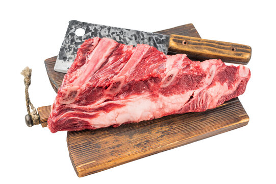 Fresh uncooked beef ribs slab with visible bones and herbs on cutting board. isolated background for BBQ cooking and butchery concepts.