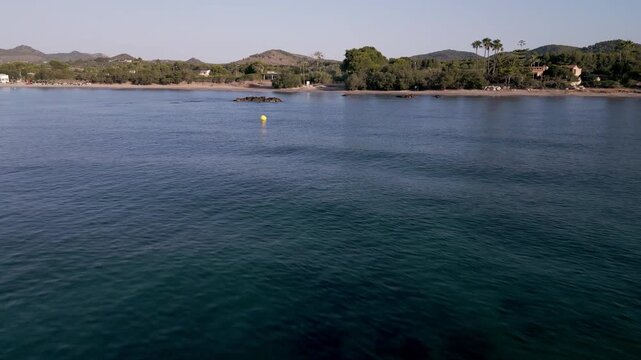 Vista a&eacute;rea de Cala Bona en Mallorca con playa, puerto deportivo y hoteles junto al mar