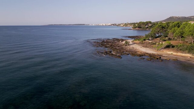 Vista a&eacute;rea de Cala Bona en Mallorca con playa, puerto deportivo y hoteles junto al mar