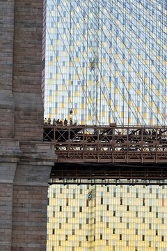 New York, United States - 04 February 2024: View of the iconic Brooklyn Bridge, its steel cables a stark contrast against the checkerboard pattern of the adjacent buildings.