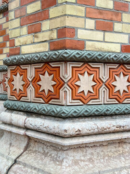 Vibrant close-up of the Dohany Street Synagogue intricate Moorish Revival facade, featuring colorful geometric eight-pointed star tiles and textured brickwork.
