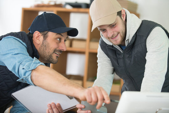two men in workshop looking at computer screen