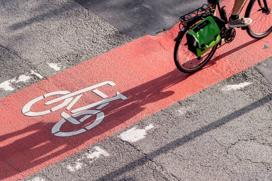 Motion of urban cyclist bicycle in bike lane with shadow on red asphalt street in Hamburg capturing speed action and city traffic