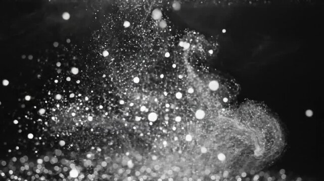 Abstract underwater explosion of water with sparkling particles creating a dynamic liquid motion against dark background