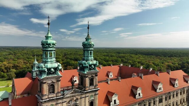 Aerial drone view of Cistercian Abbey in Lubiąż, Lower Silesia, Poland, surrounded by lush green forests, river, and scenic countryside landscape, historic monastery and cultural heritage site