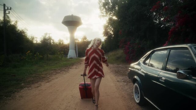 Blonde Woman In Retro Attire By Automobile. Serene Woman Resting Near Vehicle Amidst Lush Flowers