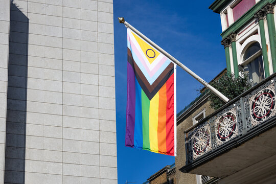 Progress pride flag hanging from a city building