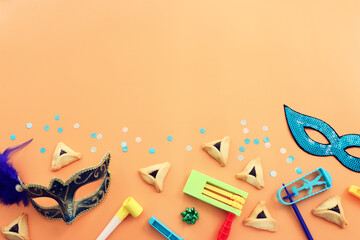 Purim celebration concept (jewish carnival holiday) over yellow background