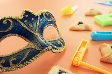 Purim celebration concept (jewish carnival holiday) over yellow background