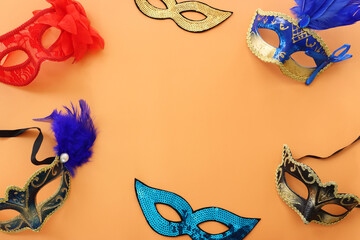 Holidays image of masquarade masks over yellow background. view from above