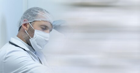 Composition of tired doctor in surgical cap and gloves and blurred copy space
