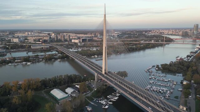 Drone slowly rotates a captures a scenic view of Ada bridge and panorama of Belgrade, Serbia. Aerial footage.